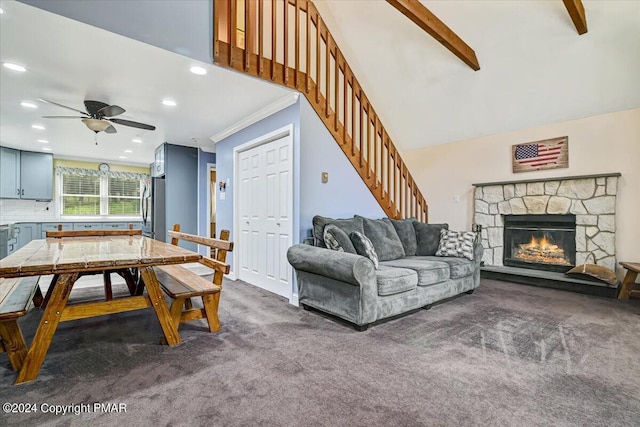 living area featuring stairway, a ceiling fan, a fireplace, crown molding, and dark carpet