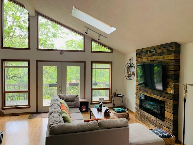 251 Dorchester Dr, Bushkill, PA 18324 - living room with lofted ceiling, a skylight, a large fireplace, wood finished floors, and french doors