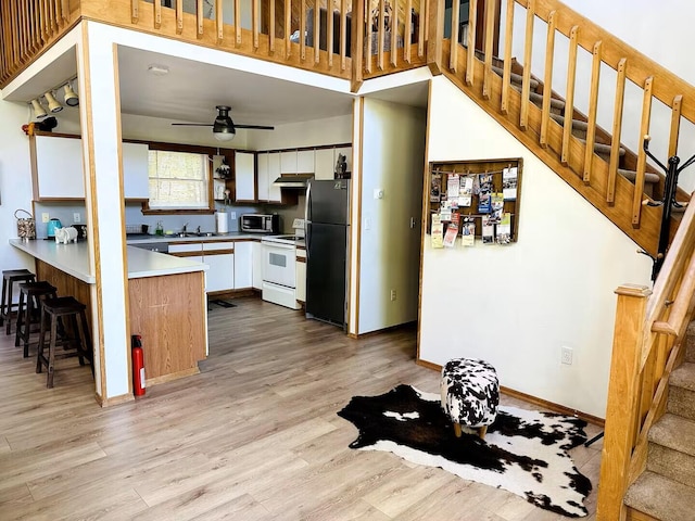 251 Dorchester Dr, Bushkill, PA 18324 - kitchen with freestanding refrigerator, electric range, a peninsula, white cabinets, and light wood-type flooring