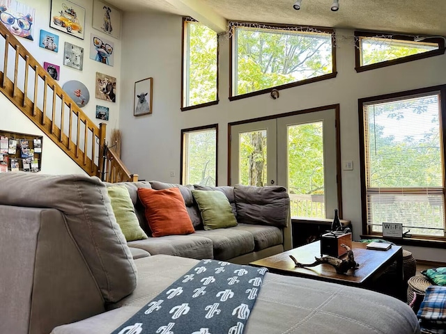 251 Dorchester Dr, Bushkill, PA 18324 - living room with stairs, high vaulted ceiling, and french doors