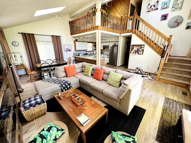 251 Dorchester Dr, Bushkill, PA 18324 - living area with a skylight, wood finished floors, stairway, and high vaulted ceiling