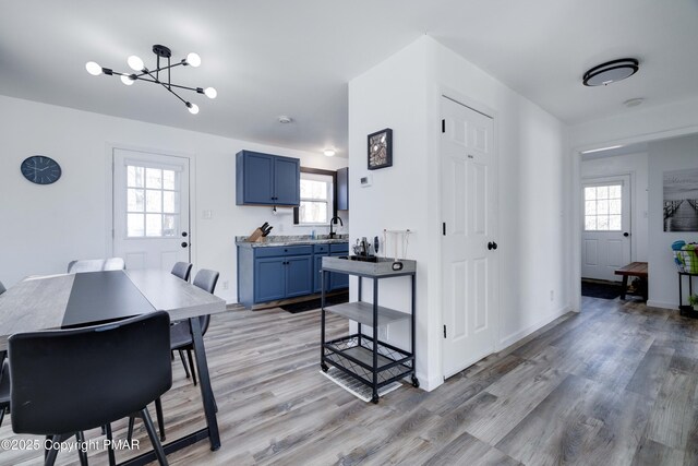 dining area featuring light wood finished floors, baseboards, and a chandelier