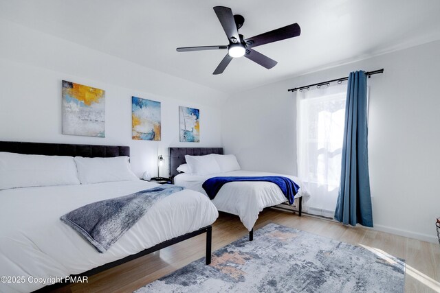 bedroom featuring lofted ceiling, a ceiling fan, and wood finished floors