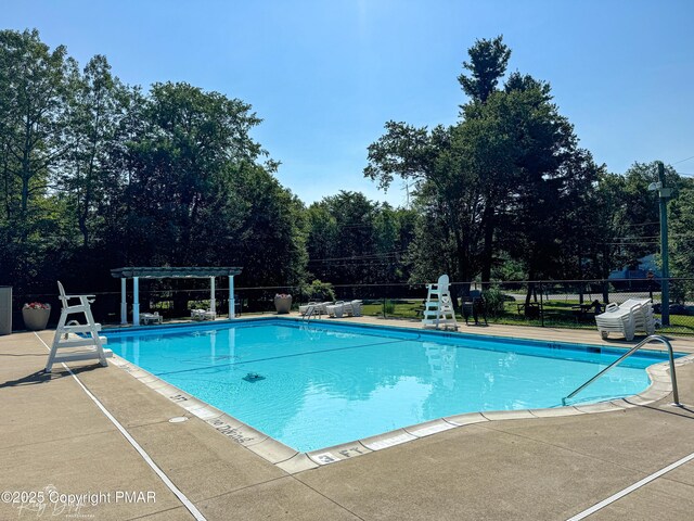 community pool featuring fence, a patio, and a pergola