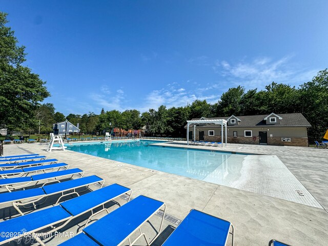 pool with a patio area, fence, and a pergola