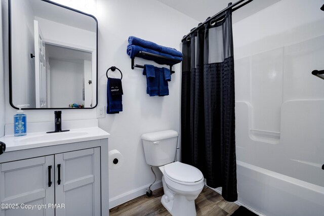 full bathroom with baseboards, toilet, wood finished floors, shower / bath combination with curtain, and vanity