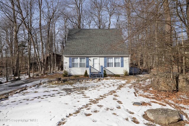 new england style home with roof with shingles