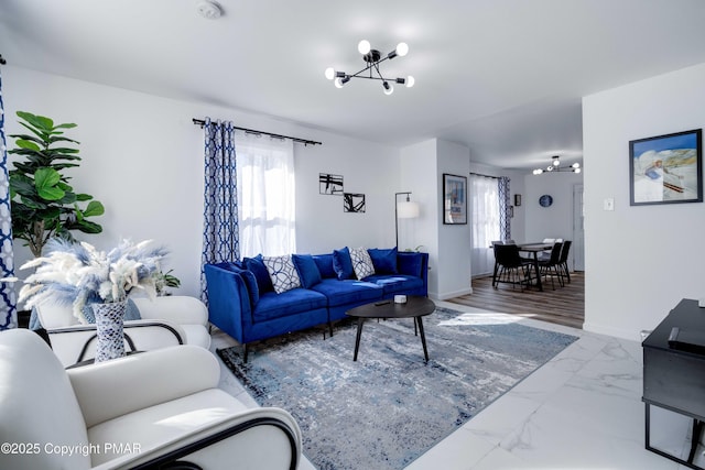 living area featuring a healthy amount of sunlight, marble finish floor, and baseboards