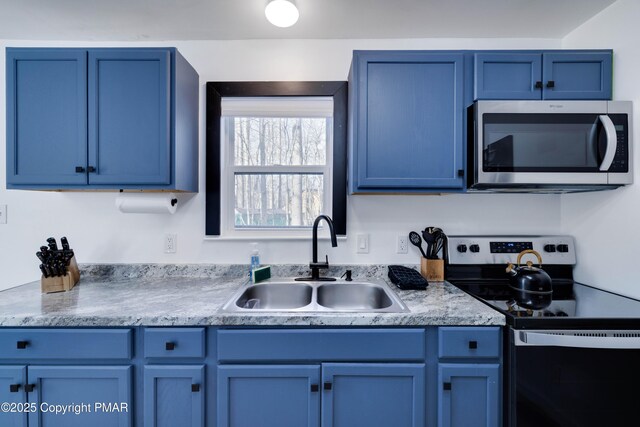 kitchen with stainless steel appliances, blue cabinetry, and a sink