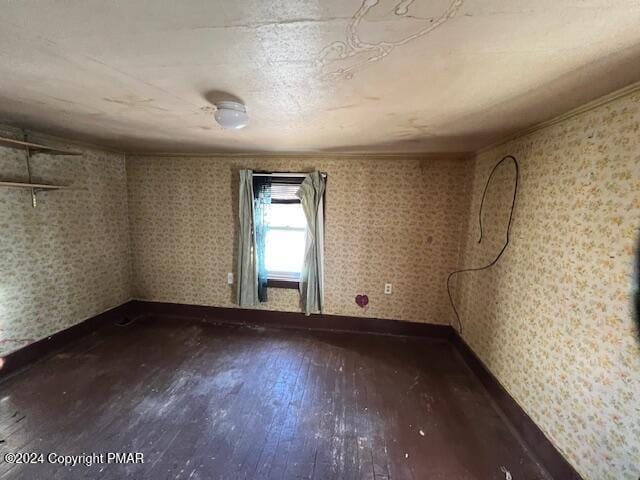 unfurnished room with crown molding, baseboards, and hardwood / wood-style floors