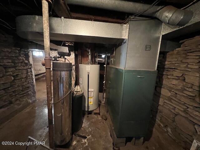 utility room featuring water heater and heating unit