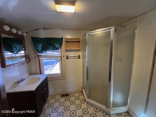 bathroom with a shower stall, vanity, and tile patterned floors