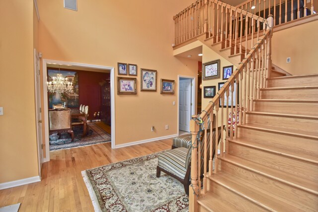210 Edwin Ln, Stroudsburg, PA 18360 - stairs featuring a high ceiling, baseboards, a chandelier, and wood finished floors