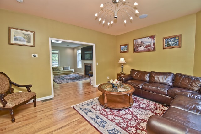 210 Edwin Ln, Stroudsburg, PA 18360 - living room with a chandelier, light wood-style flooring, baseboards, and a glass covered fireplace