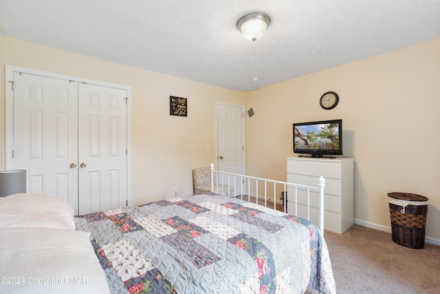 bedroom featuring carpet floors, a textured ceiling, baseboards, and a closet