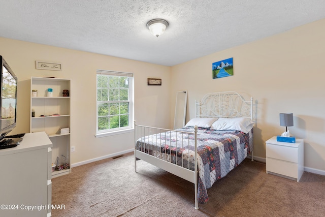 carpeted bedroom featuring visible vents, a textured ceiling, and baseboards