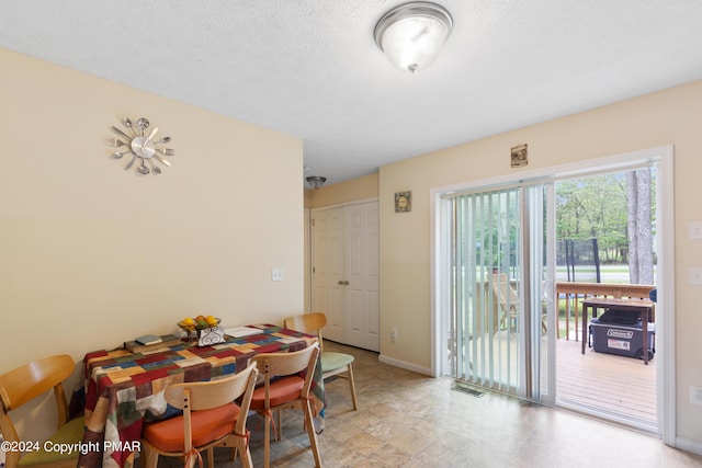 dining space with baseboards, visible vents, and a textured ceiling