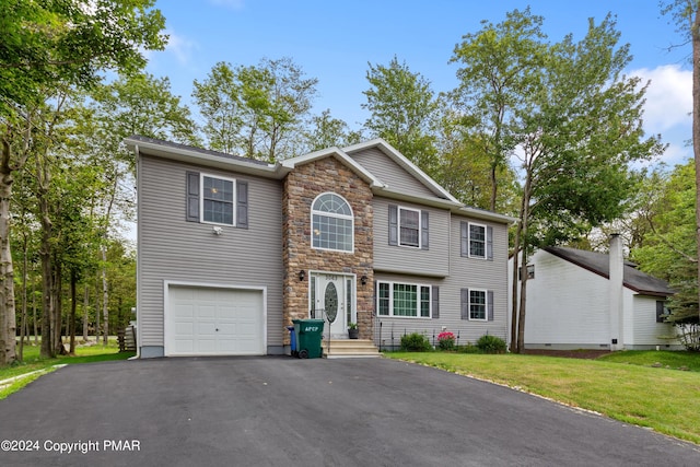 view of front facade with aphalt driveway, a front yard, stone siding, and a garage