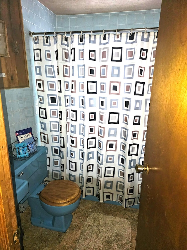 bathroom with a shower with shower curtain and toilet