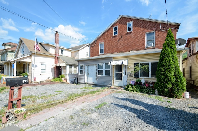 view of front facade with gravel driveway and brick siding