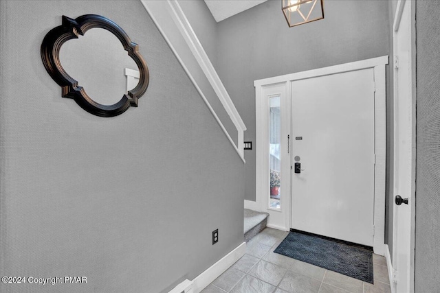 foyer featuring stairs, tile patterned flooring, and baseboards