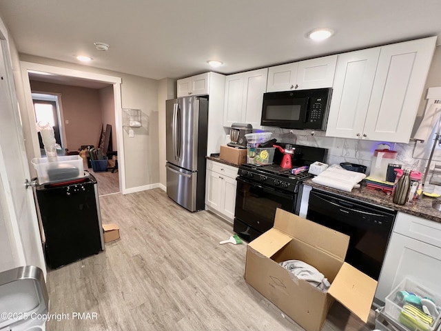 kitchen featuring white cabinetry, black appliances, light wood-type flooring, and baseboards