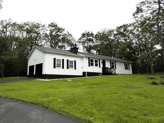 3015 Mountain Ter, Stroudsburg, PA 18360 - view of front of home featuring a chimney, a garage, a front lawn, and asphalt driveway