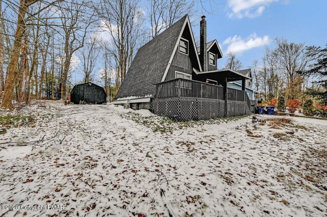 snow covered back of property with a porch