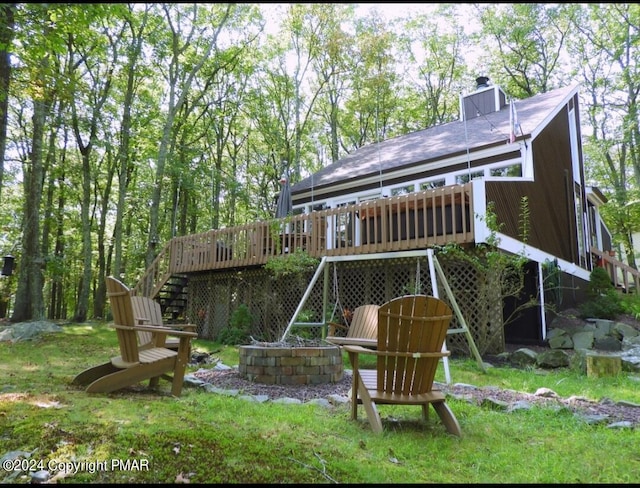 view of playground with a yard, stairs, and a wooden deck