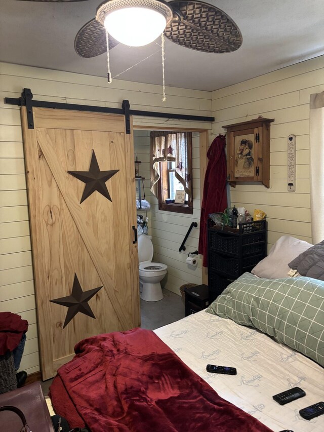 82 Pocono Rd, Albrightsville, PA 18210 - bedroom featuring wooden walls, ensuite bath, and a barn door