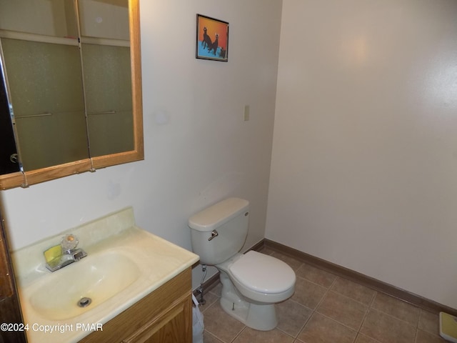 bathroom with tile patterned flooring, toilet, vanity, and baseboards