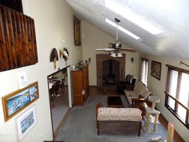 living room with ceiling fan, lofted ceiling, a wood stove, and a textured ceiling