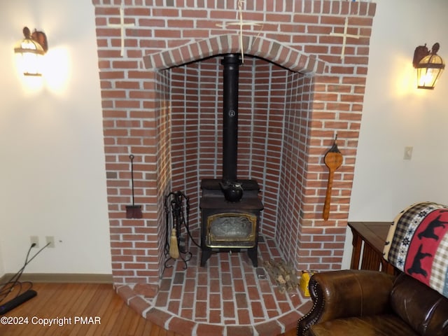 details with baseboards, wood finished floors, and a wood stove