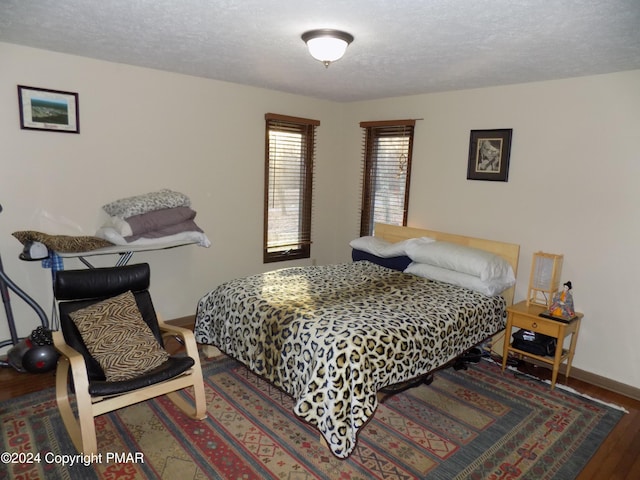 bedroom featuring dark hardwood / wood-style floors and a textured ceiling