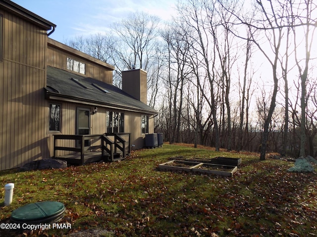 view of yard featuring a garden, central air condition unit, and a deck