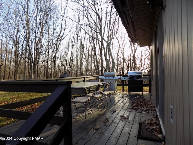 wooden deck with grilling area and outdoor dining space