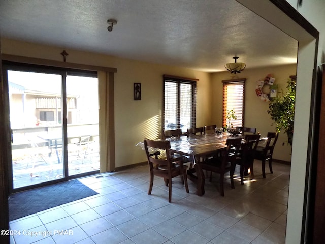 dining space with light tile patterned floors and a textured ceiling