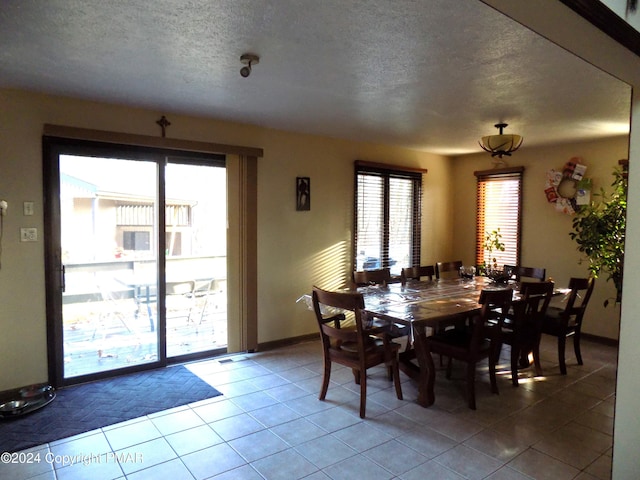 dining room featuring tile patterned floors and a textured ceiling