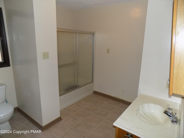 bathroom featuring baseboards, bath / shower combo with glass door, toilet, tile patterned floors, and vanity