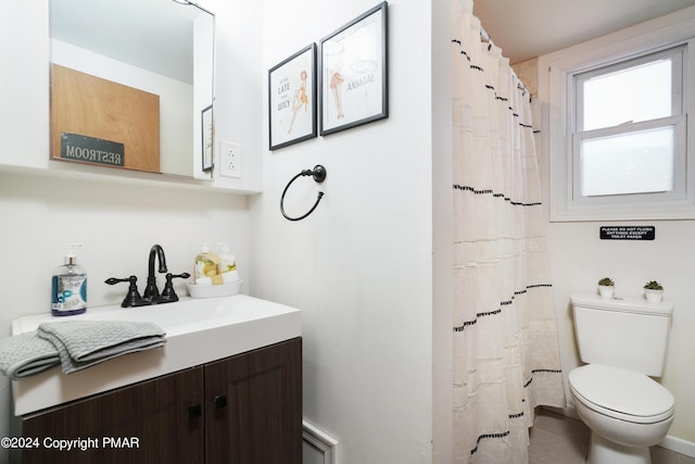 bathroom featuring toilet, a shower with shower curtain, and vanity