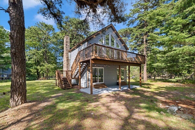 back of property featuring a patio, a yard, a chimney, stairs, and a deck