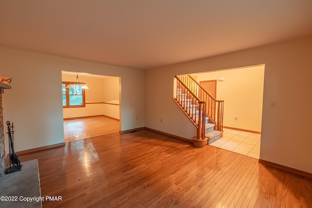 unfurnished living room featuring light hardwood / wood-style flooring and a chandelier