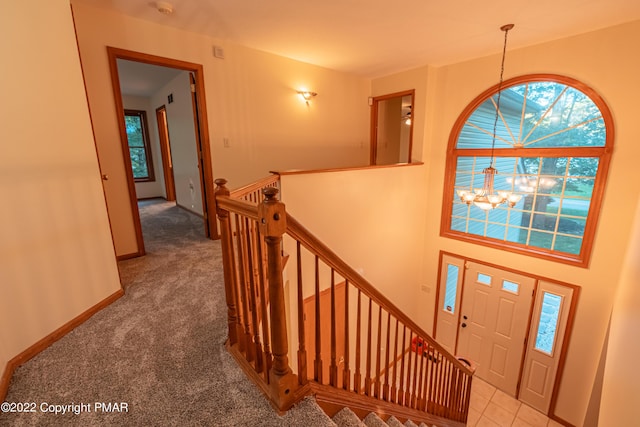 foyer featuring carpet flooring and a notable chandelier