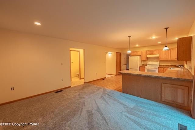 kitchen featuring pendant lighting, light brown cabinetry, sink, kitchen peninsula, and white appliances