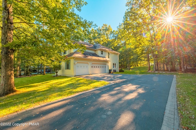 view of property exterior with a garage and a lawn