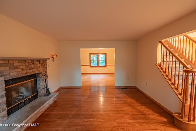 unfurnished living room with hardwood / wood-style flooring and a fireplace