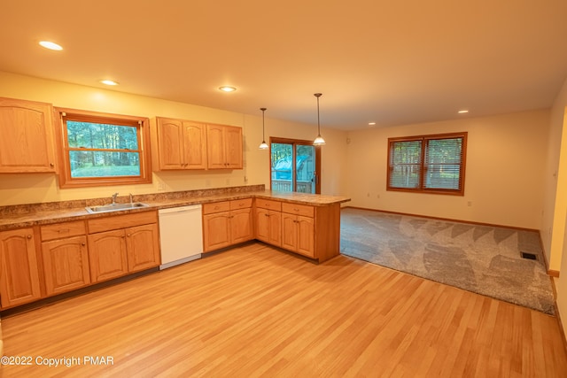 kitchen featuring pendant lighting, sink, white dishwasher, light hardwood / wood-style floors, and kitchen peninsula