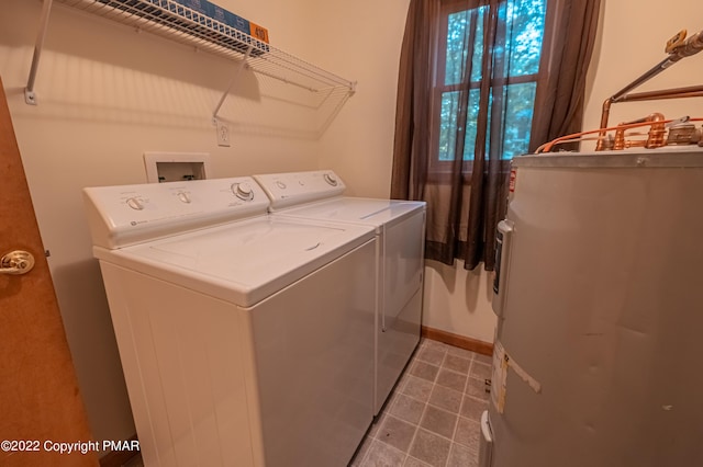 clothes washing area featuring water heater and washing machine and clothes dryer