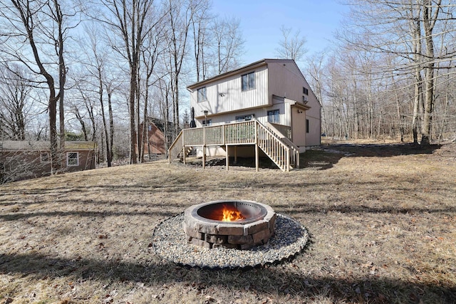back of property with an outdoor fire pit, stairs, and a deck
