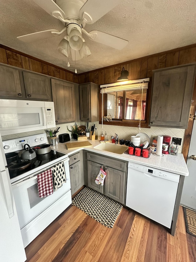 kitchen featuring white appliances, light countertops, a ceiling fan, a textured ceiling, and a sink